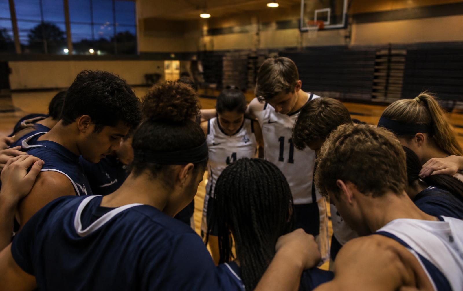 Student athletes gathered in a huddle